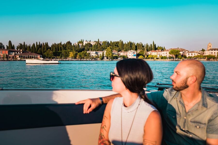 Sirmione: 25 Minute Boat Cruise around the Peninsula - Piazzale Porto, blue umbrella, and Mr. Claudio: getting on the boat